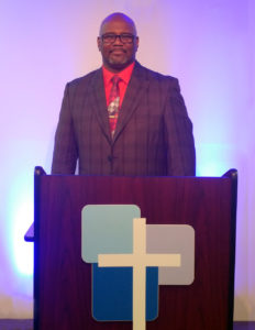 Pastor DeCarlo Sabedra standing in front of the podium